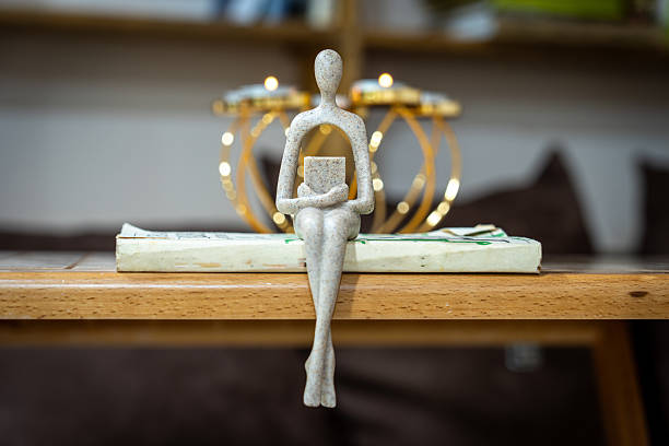 A figure sitting on a book with a book in his hands