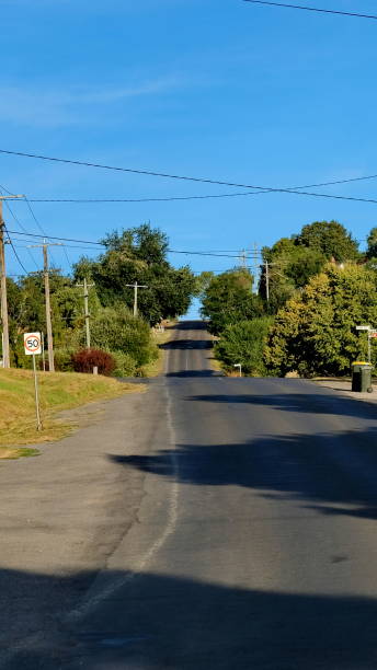 Quiet Suburban Road with Rolling Hills and Lush Greenery