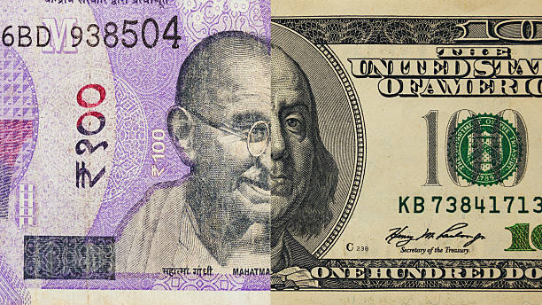 istock Half of a 100 rupee and 100 dollar note 2202633683