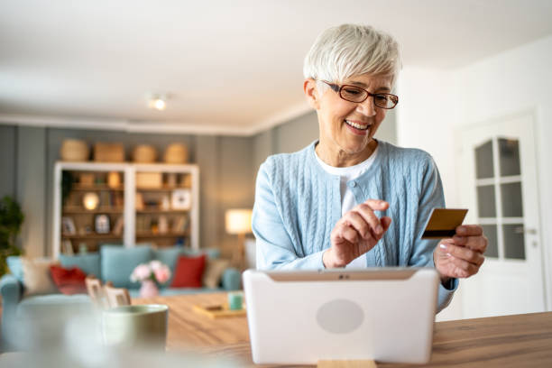 istock Elderly woman using her tablet to shop online 2202635600