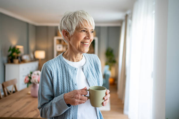 istock Short-haired older woman drinking her morning coffee 2202636533