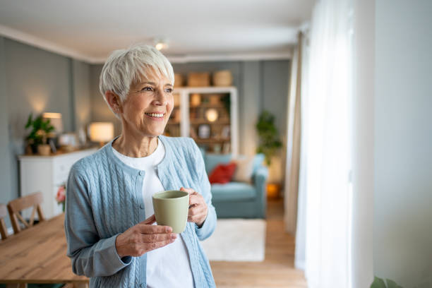 Short-haired older woman drinking her morning coffee