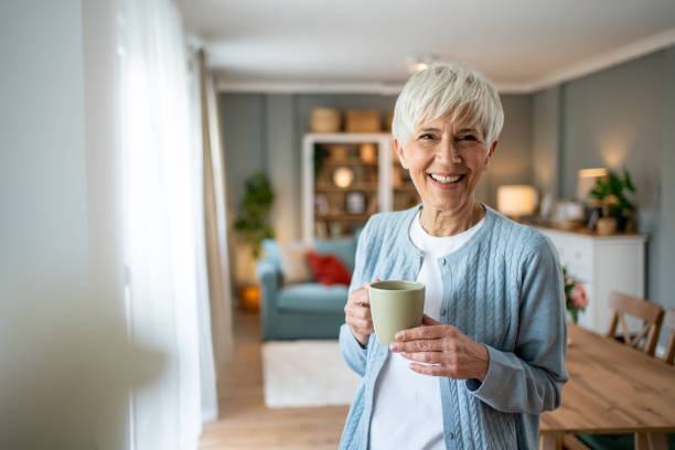 istock Senior woman with coffee, smiling at the camera 2202636564