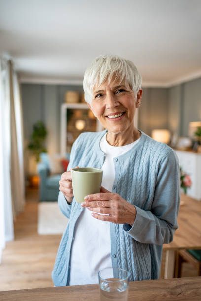 istock Senior woman with coffee, smiling at the camera 2202636567