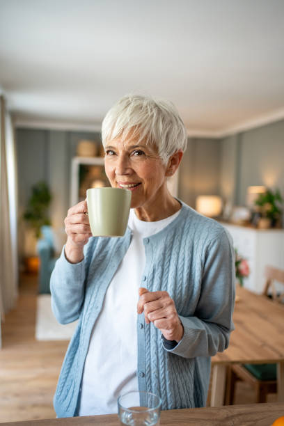 istock Senior woman with coffee, smiling at the camera 2202636571