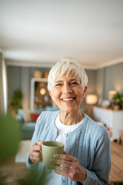 istock Senior woman with coffee, smiling at the camera 2202636572