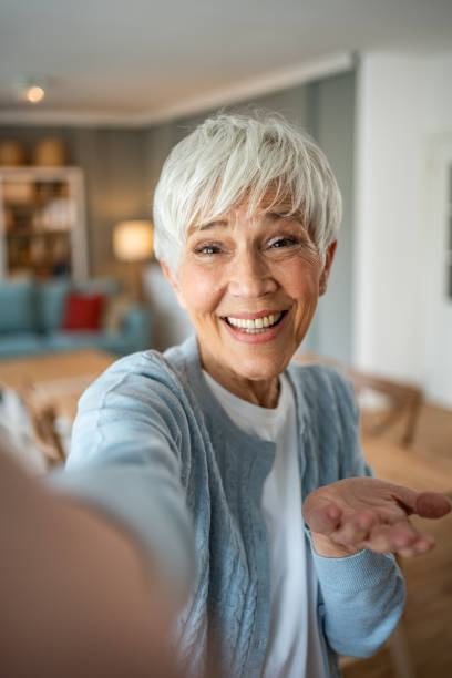 istock Happy senior woman making a selfie at home 2202636711