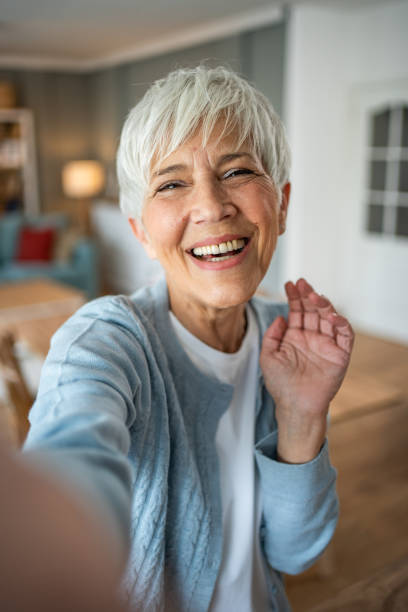 istock Happy senior woman making a selfie at home 2202636715