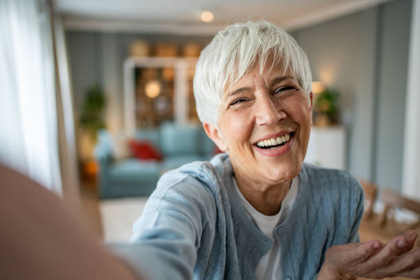 istock Happy senior woman making a selfie at home 2202636731