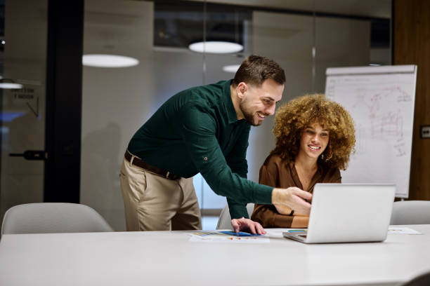 istock Business colleagues collaborating on a project, analyzing data on a laptop in a modern office 2202637893