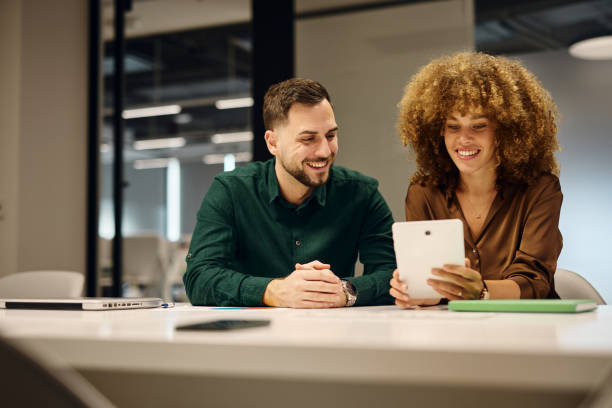 istock Business people using tablet and smiling in modern office 2202637985