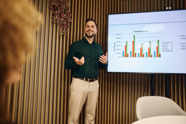 Young businessman presenting sales data to his colleagues in a modern office