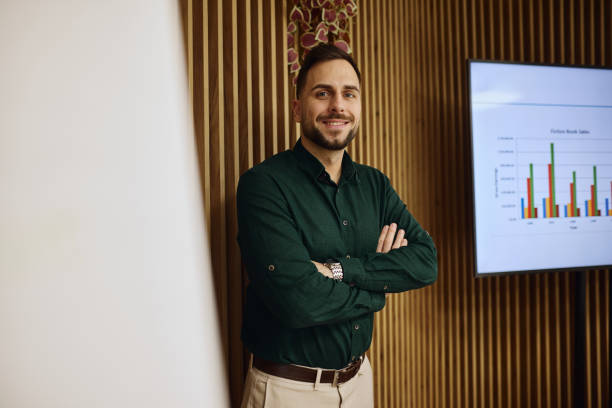 istock Young businessman smiling with arms crossed in modern office during presentation 2202638192