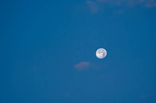 The moon obscured by clouds against the night sky in Northumberland