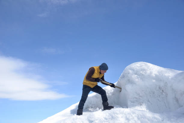 istock An old man removing snow with a shovel 2202638736