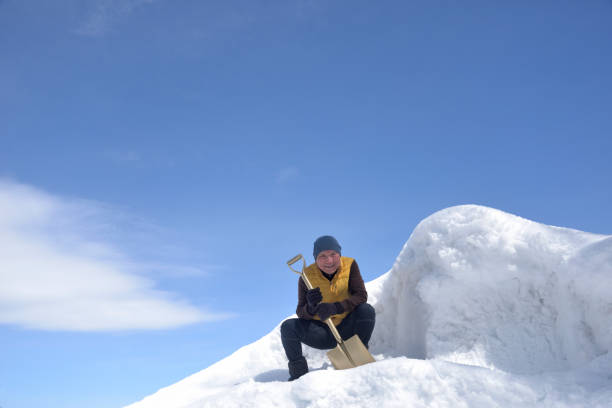 istock An old man removing snow with a shovel 2202638738