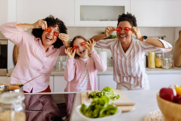istock Smiles All Around: A Happy Kitchen Scene with Two Moms and Their Child 2202638977