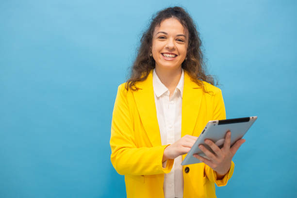 istock Smiling businesswoman using a tablet with a blue background 2202640913