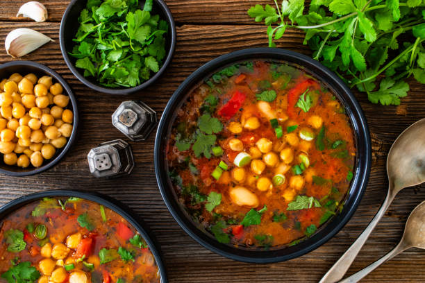 istock Fresh vegetable soup with chick-pea served in white bowl on wooden table 2202641736