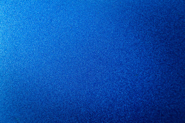 istock Blue abstract surface with grainy texture. A blue matte background with focus in the middle and blurring at the top and bottom. 2202645191