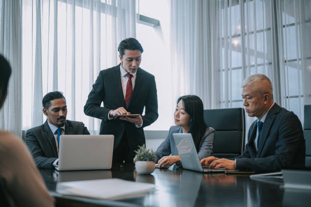 istock Asian Chinese young businessman explaining showing solution in sales pitch meeting discussion in meeting room 2202646041