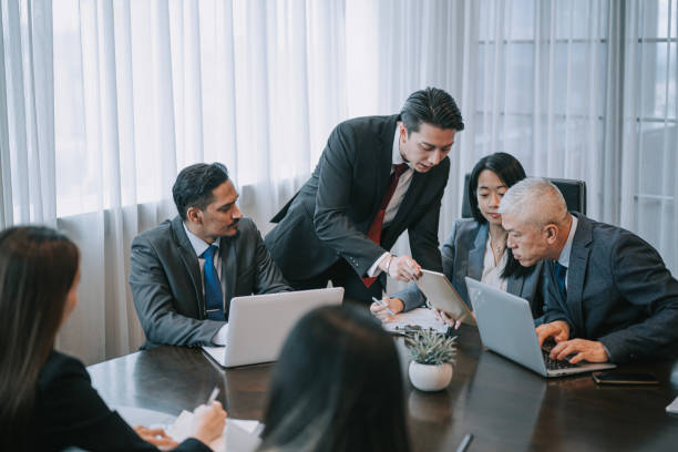 istock Asian Chinese young businessman explaining showing solution in sales pitch meeting discussion in meeting room 2202646556