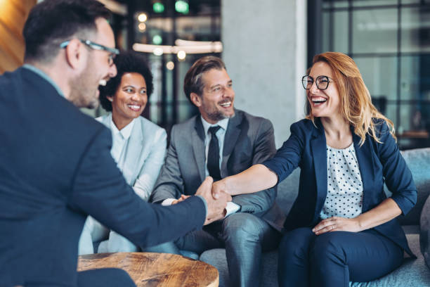 istock Cheerful businesspersons greeting each other in the office 2202655449