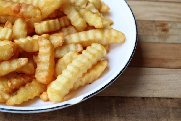 istock French fries on wood background 2202657226