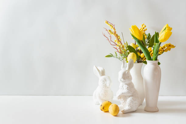 istock A white vase of yellow tulips and eggs on a white table 2202657672