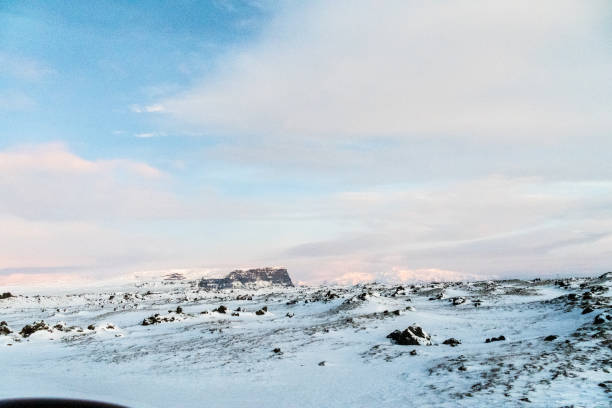 A beautiful snowy winter landscape from southern Iceland, basking in the beautulf soft pink light of a low hanging sun. Winterdays in Iceland are marked by a perpetual golden hour.