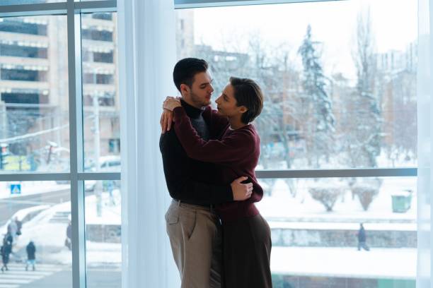 istock Couple embraces warmly inside bright, modern space during winter season 2202660193