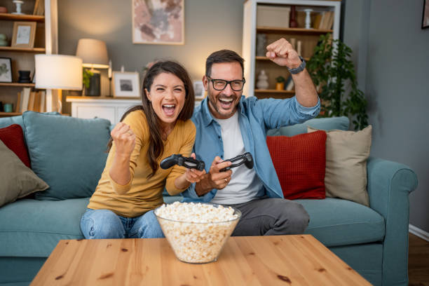 istock Cheerful couple playing video games at home 2202663035