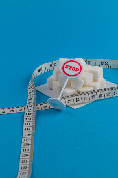 istock Preventing sugar overload with measuring tape and stop sign on blue background 2202663240