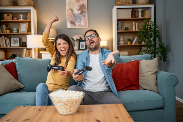 istock Excited couple playing video games at home 2202663300