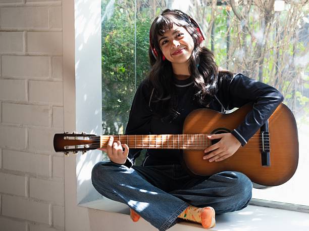 istock young left-handed woman practicing guitar 2202663675