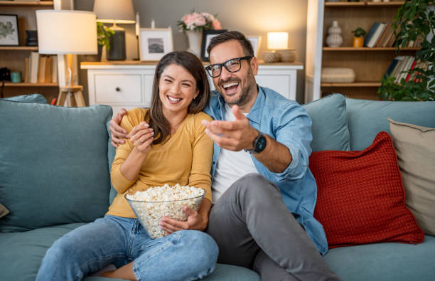istock Young couple watching tv at home 2202665015