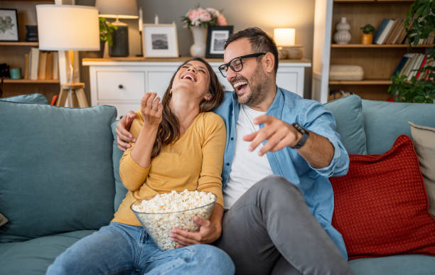 istock Young couple watching tv at home 2202665027
