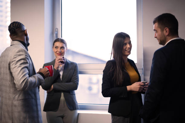 istock Business professionals networking during a coffee break in a modern office. Concept of corporate communication, teamwork, and professional relationships in a workplace setting 2202665268
