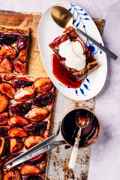 Overhead view of a dish of spiced plum and marzipan tart. Served with creme fraiche.