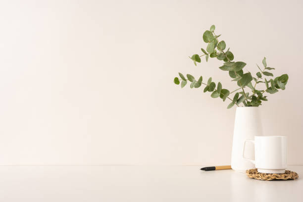 istock Simple and peaceful arrangement featuring a eucalyptus branch in a white vase beside a mug 2202668683