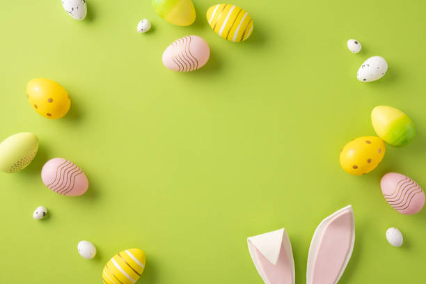istock Easter-themed flat lay featuring colorful eggs and cute bunny ears over a green backdrop, perfect for seasonal celebrations 2202668703