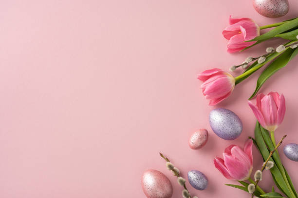 istock Spring-themed arrangement of pink tulips, speckled Easter eggs, and pussy willow branches on a pastel pink setting, evoking Easter and seasonal decoration vibes 2202668707