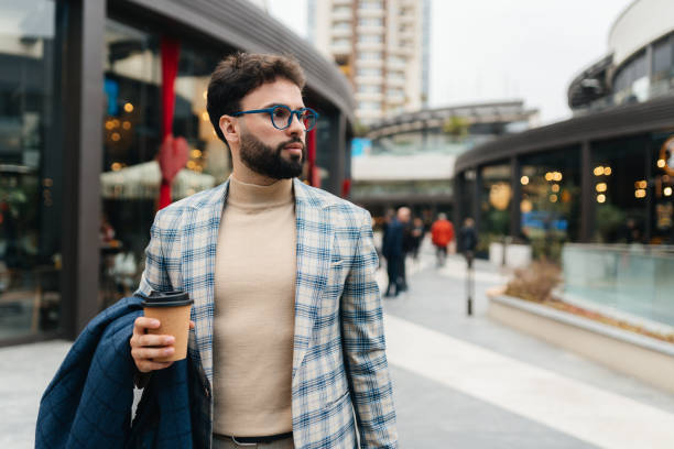 istock Stylish Young Man Walking in the City with Coffee 2202672014