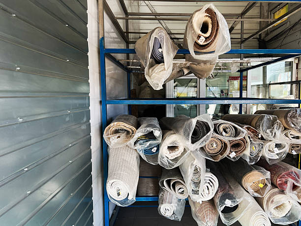 istock Assorted rolled carpets displayed on shelving in an industrial-style storage space 2202673730