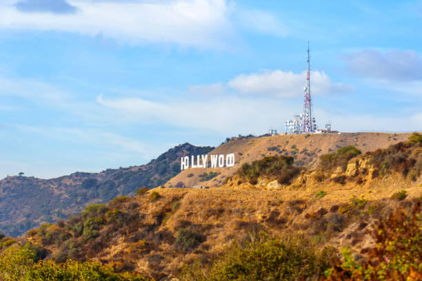 Los Angeles, California - December 14, 2024: Close-up view of the famous Hollywood Sign on hillside with a transmission tower, framed by picturesque clouds and rolling terrain.