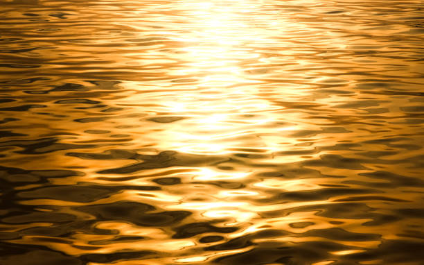 istock Beautiful sunlight reflection of gold water. Moonlight reflects on the water surface surface​ gold​ water background. abstract golden textured background. 2202678252