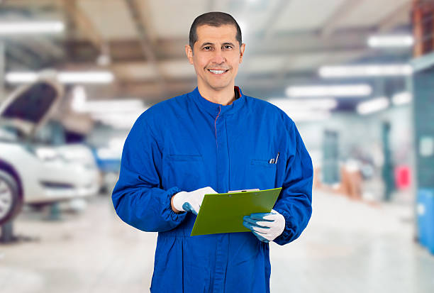 istock repairman smiling and holding clipboard at the workshop 2202678600