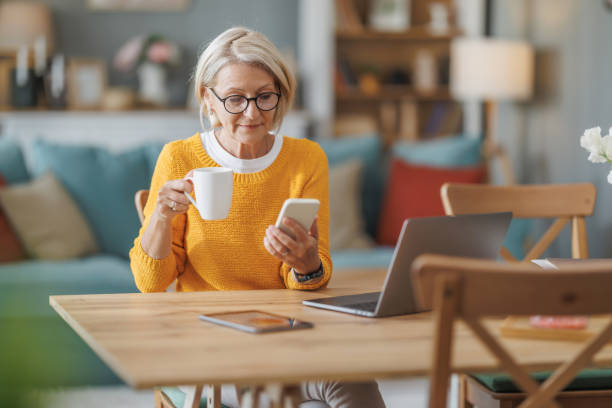 istock Woman enjoying coffee while browsing on smartphone at home workspace during the morning 2202678769