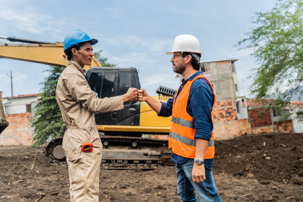 istock Engineer and employee touch fists at a construction site 2202680419
