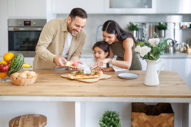 istock Family enjoys cooking together in a bright kitchen while preparing fresh pizza for dinner 2202681465